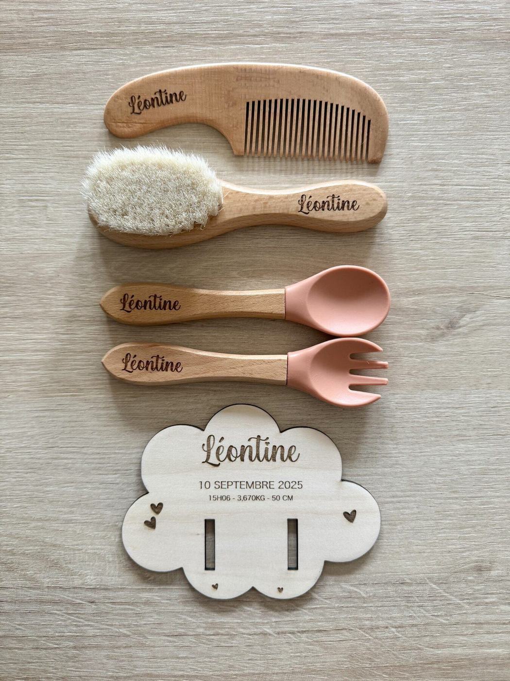 Détail des accessoires en bois gravés au prénom Léontine : peigne, brosse, cuillère et fourchette